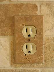 Installed travertine electrical outlet cover plate