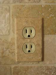 Installed travetine outlet cover plate